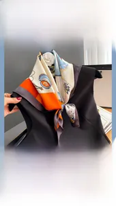 Détail d'un carré de soie élégant aux imprimés bijoux et fleurs sur un haut noir