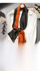Narrow silk scarf with polka dot and floral prints styled on a white shirt collar