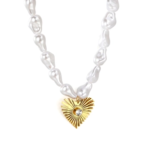 Collier en perles baroques avec pendentif cœur doré à motifs radiaux et pierre zircon