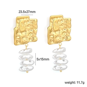 Détail de boucles d'oreilles papillon dorées avec accents blancs et mesures
