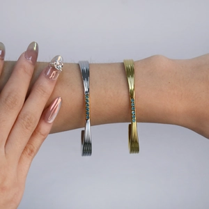 Détail de bracelets plaqués or 18 carats et argent avec cristaux bleus et solitaire