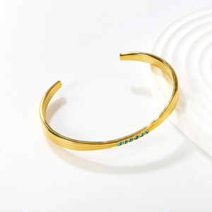 Bracelet manchette plaqué or 18 carats avec pierres bleues et bordures à rayures