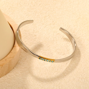 Bracelet en C en acier argenté avec bande dorée et cristaux bleus incrustés de luxe