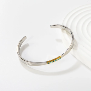 Bracelet jonc ouvert minimaliste en acier argenté avec accents dorés et saphirs bleus