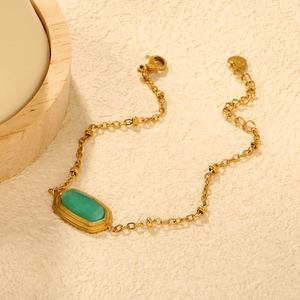Gold plated stainless steel beaded bracelet featuring a rhombus emerald green stone centerpiece