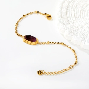 Detailed view of 18k gold plated stainless steel bracelet with purple rectangular gemstone
