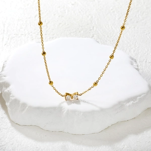 Collar elegante de acero inoxidable dorado con lazo de cristal en base de piedra