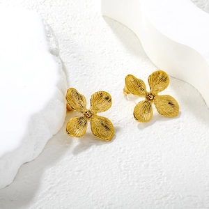 Élégantes boucles d'oreilles fleurs à quatre pétales en acier doré sur décor pierre