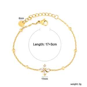 Macro shot of gold stainless steel bracelet featuring zircon-inlaid four-petal flower charm