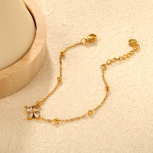 Detail of gold-plated stainless steel bracelet with flower zircon charm and lobster clasp