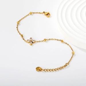Detail of gold four-leaf clover bracelet with sparkling zircon and lobster clasp closure