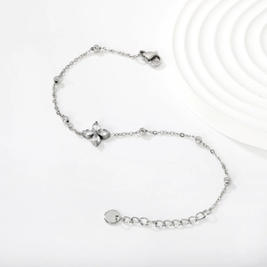 Close-up of stainless steel bracelet with clover zircon charm and S.STEEL stamp