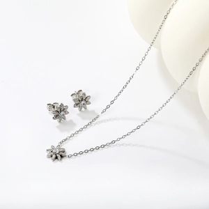 Detailed macro view of silver flower necklace and studs with sparkling white zircon