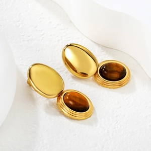 Detailed view of vintage gold earrings with oval tiger eye stone in polished 18k setting