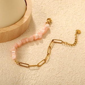 Détail du bracelet avec perles en nacre rose et chaîne trombone en acier inoxydable doré