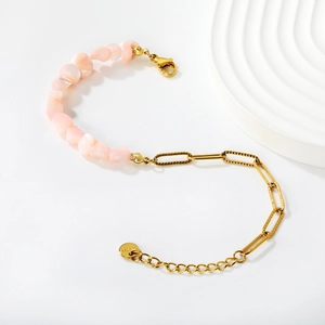Détail du bracelet en nacre rose et chaîne trombone dorée avec fermoir mousqueton
