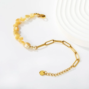 Détail de la chaîne trombone dorée et des fragments de nacre jaune avec fermoir en acier inoxydable