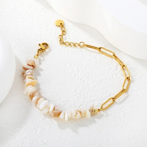 Détail d'un bracelet composé de pierres de cristal naturel et d'une chaîne trombone dorée