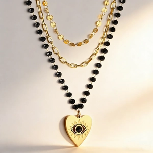 Three-layer layered necklace with heart evil eye pendant and black beads in 18K gold finish