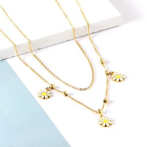 Détail du collier double rang avec fleurs de marguerite en émail sur chaîne dorée élégante