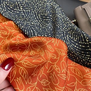 Detailed view of satin floral scarf with silk texture and elegant drape patterns