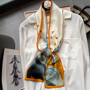 Fashionable silk scarf with bird pattern tied on a white shirt in a minimalist style
