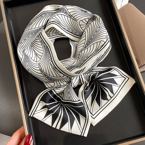 Foulard étroit en soie blanc et noir avec motifs géométriques noué en boucle