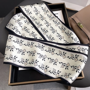 Détail macro d'un foulard en soie avec motifs de vignes et fleurs roses