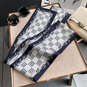 Détail d'un foulard mince à motif pied-de-poule bleu et gris avec texte décoratif