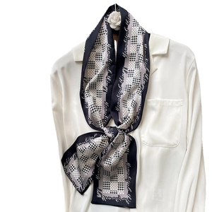 Écharpe étroite classique à motif pied-de-poule noir et blanc sur un col de chemise blanc