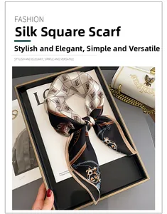 Detail of silk square scarf featuring horse head pattern on a luxury tray display