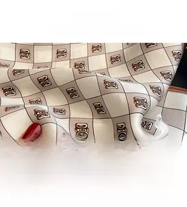 Detailed close-up of smooth silk fabric with horse carriage pattern and elegant texture
