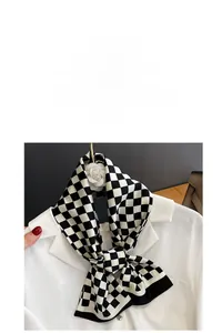 Détail d'un foulard en soie à damier noué sur un col de chemise blanc en satin brillant