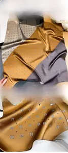Macro detail of silk scarf showing precise edge stitching and geometric dot pattern
