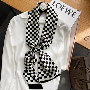 Élégant foulard en soie à damier noir et blanc noué sur un col de chemise blanc