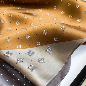 Detail of silk scarf showing geometric diamond patterns and golden color blocking