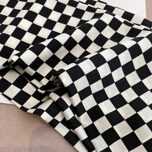Texture détaillée du tissu d'écharpe en soie à damier noir et blanc avec plis élégants