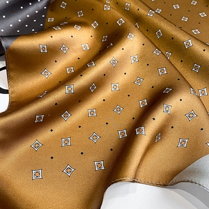 Detailed view of silk square scarf featuring golden geometric texture and polka dot patterns