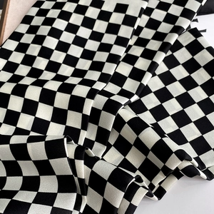 Vue rapprochée de la texture satinée soyeuse avec un motif à damier noir et blanc classique