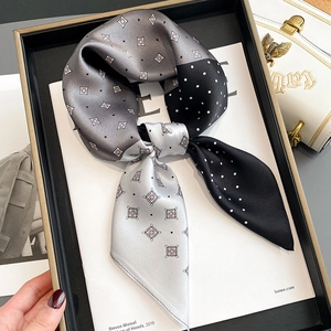 Polka dot and plaid patchwork silk scarf displayed on a luxury tray with a handbag