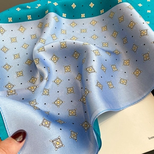 Close-up of silk square scarf featuring geometric diamond patterns and fine edge stitching