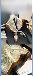 Detail of silk scarf with botanical leaf prints and elegant color-block hem stitching