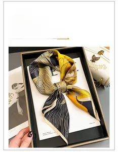 Detail of yellow and black silk square scarf with floral patterns on a display tray