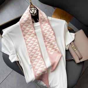 Detailed view of pink and white geometric silk twilly scarf with HAPPY text on a white shirt