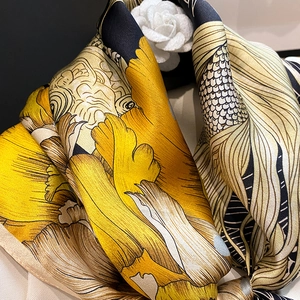 Detail of silk scarf showing floral print and premium satin texture with camellia