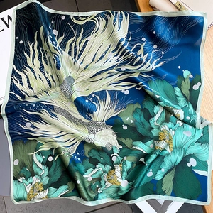 Detail of silk square scarf with dark blue koi fish and peony print on wooden surface