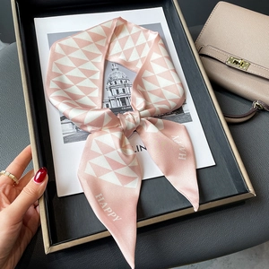 Pink and white geometric skinny silk scarf tied in a bow with HAPPY lettering detail