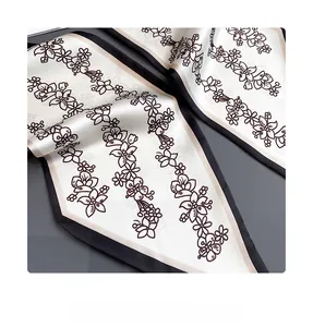 Gros plan d'un foulard en soie à fleurs montrant la couture intérieure et la texture lisse