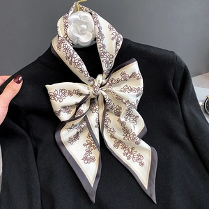 Foulard étroit en soie à motif floral ivoire avec bordure grise noué en nœud élégant