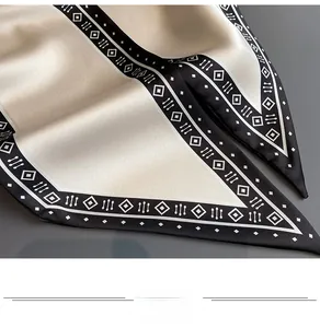 Detailaufnahme von Seidenschal mit geometrischem Muster in Beige und Schwarz mit Glanz